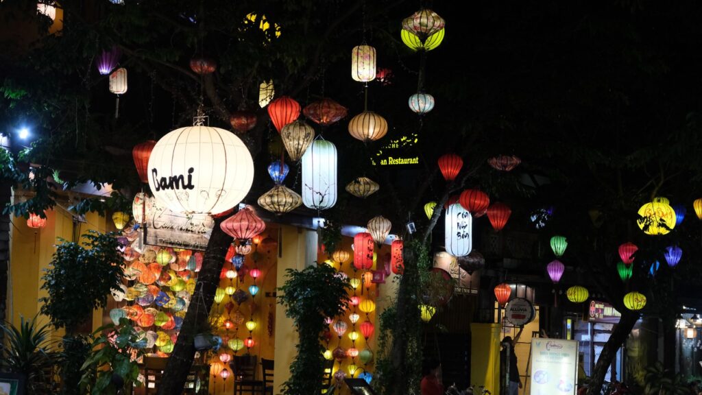 Beleuchtete Lampions über einer Gasse in der Altstadt von Hoi An am Abend